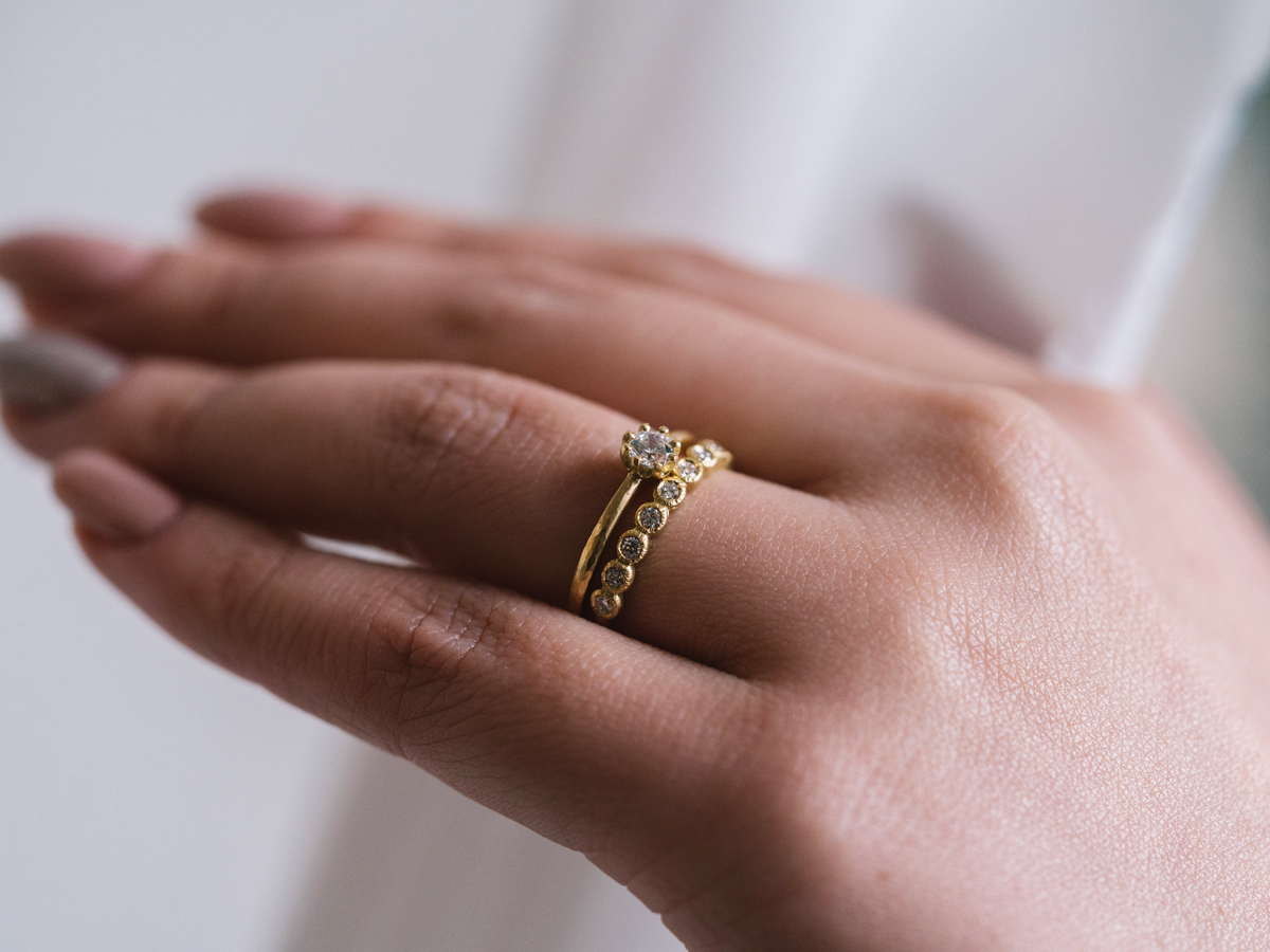 広島県福山市と広島県広島市のブライダルジュエリー専門セレクトショップヴァニラのゴールドの婚約指輪と結婚指輪を重ねて試着