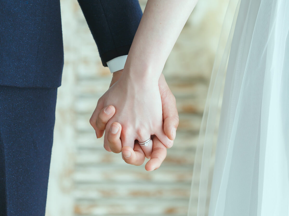 結婚式で手を繋いでいるカップル